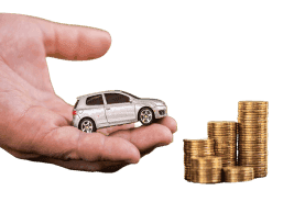 Hand holding car next to stack of coins